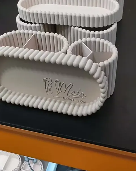 Organizador de mesa bege impresso em 3D, com a logo Maia na frente